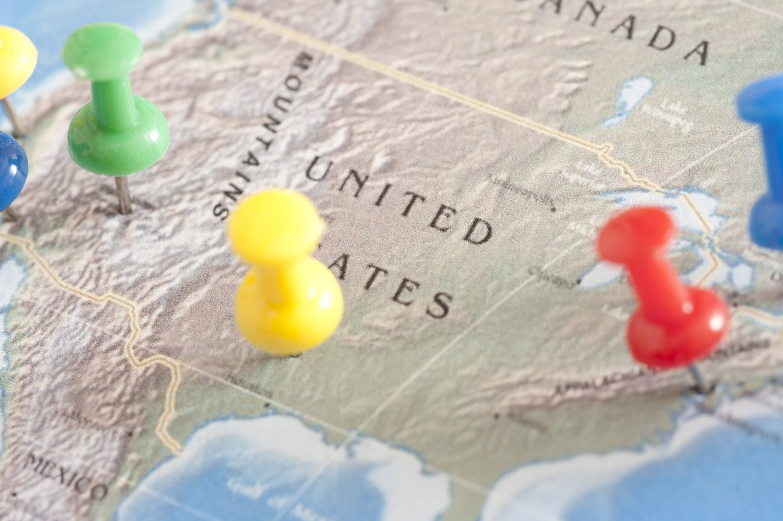US Travel Concept - Close up Shot of Conceptual Three Colored Pins on United States Map.