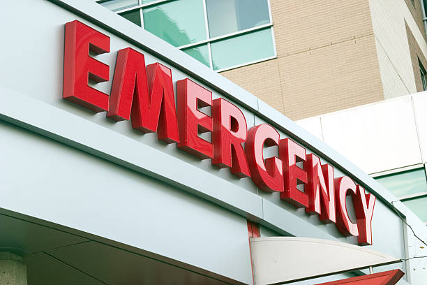 Large red EMERGENCY sign on hospital entrance. Raw original.